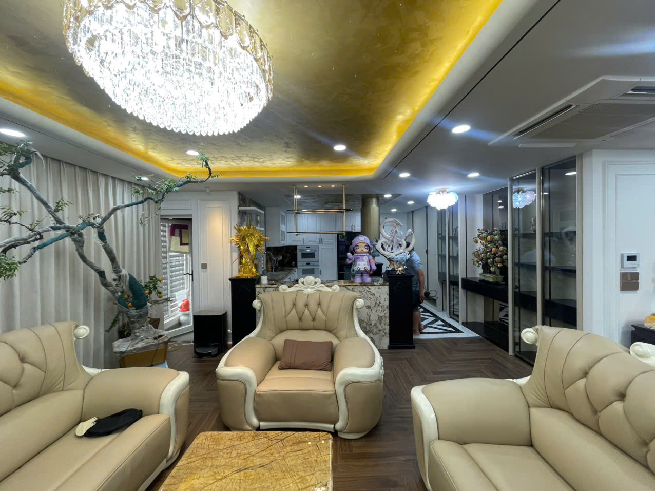 Ánh sáng lung linh từ đèn chùm pha lê cao cấp phản chiếu lên lớp vàng gương, tạo nên bầu không khí hoàng gia.